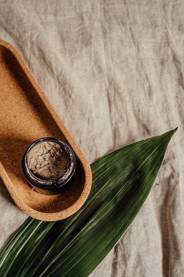 Minimalist flat lay of a skincare jar with natural textures, perfect for eco-friendly beauty brands.